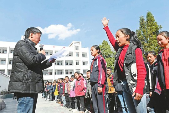 2月25日，越西县南箐镇中心小学开学典礼上，校长耿道杨拿着学籍名册逐一点名。 记者 李向雨 摄